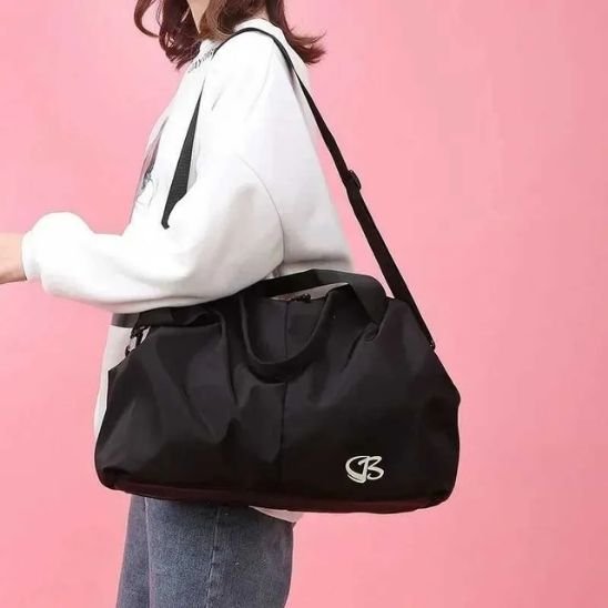 Sac de sport noir porté a l epaule par la femme