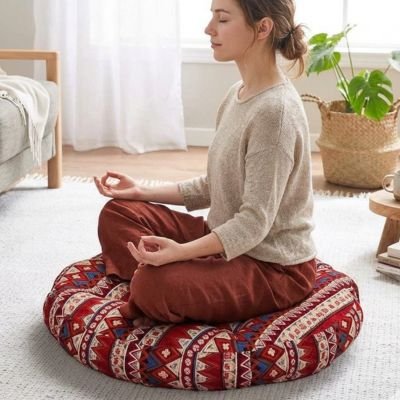 Zafu femme sur coussin yoga rouge en médiation